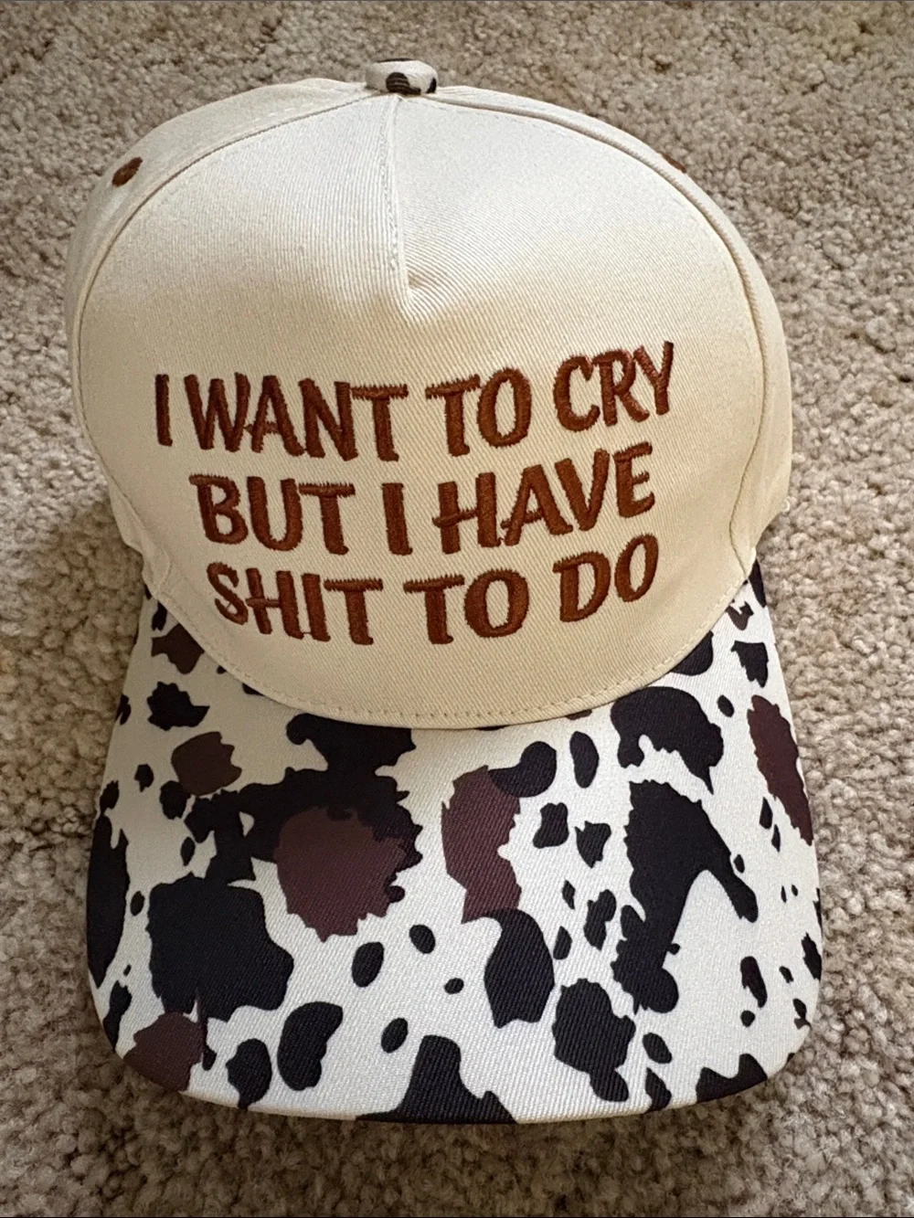 Embroiled Cream and Brown Cow Print Trucker Hat with Bold Quote